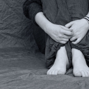 Gros plan sur les jambes d'un ado replié sur lui-même